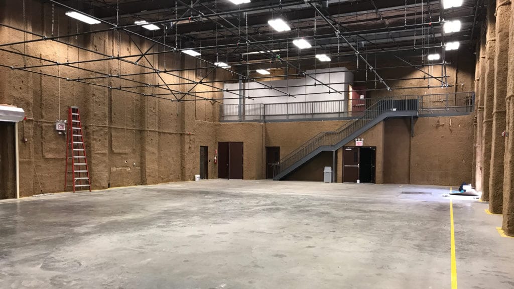Empty column-free South Stage at Annex 302 in Brooklyn, with overhead lighting grid and mezzanine