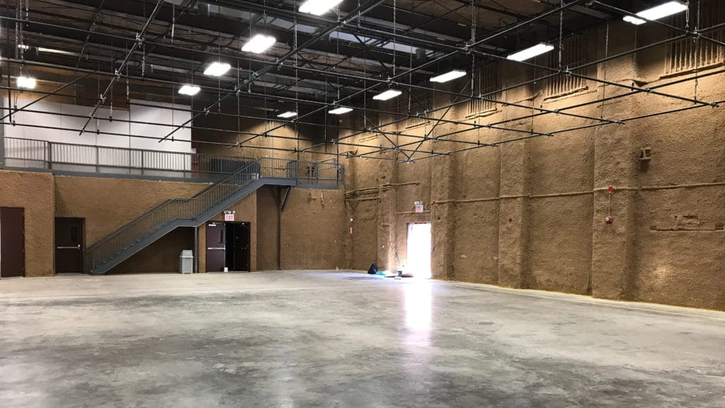 Empty column-free South Stage at Annex 302 in Brooklyn, with overhead lighting grid and mezzanine