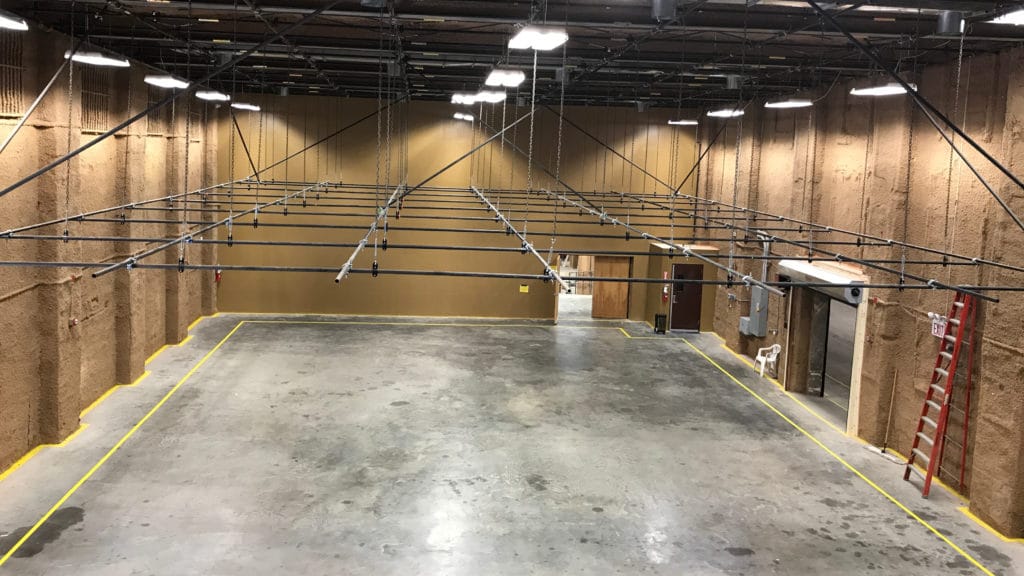 Empty South Stage at Annex 302 in Brooklyn looking toward the loading doors, with overhead lighting grid