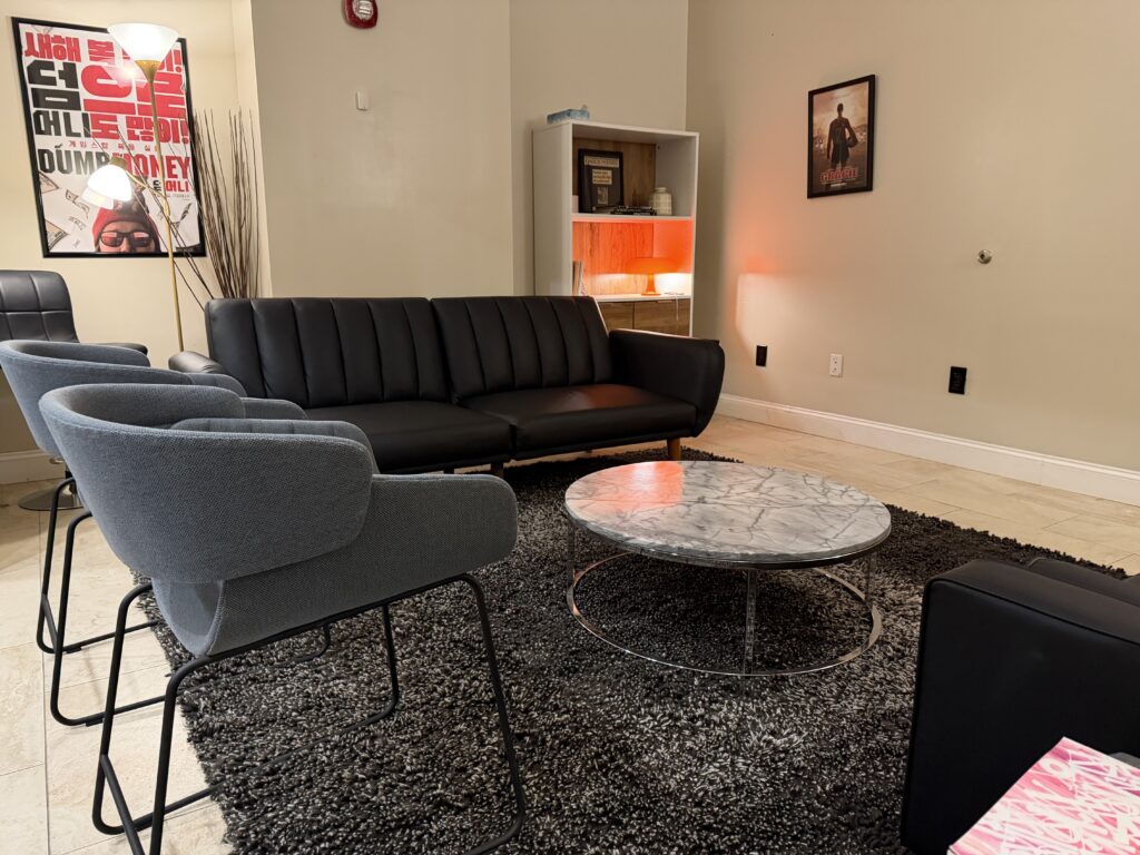 Client lounge at Annex 302 with sofas, armchairs and framed film posters